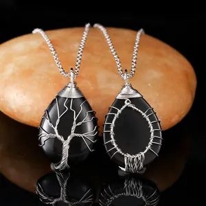 Macro view of handmade wire-wrapped tree of life pendants with black natural stone.
