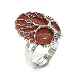 Detail of a handmade silver wire wrapped tree of life ring with oval goldstone cabochon