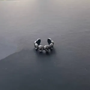 Detailed close-up showing the intricate texture of a gothic skull ring in dark metallic