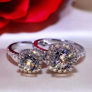 Vista macro de dos anillos halo brillantes con diamantes micro-pavé y piedras centrales.