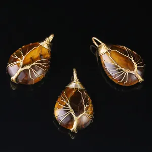 Detail view of handmade tree of life wire wrapped natural tiger's eye teardrop pendants.