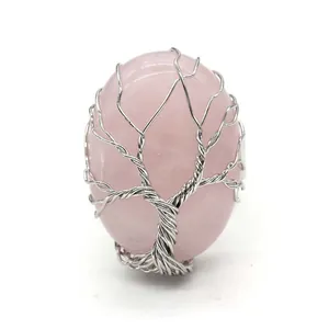Detailed view of silver wire-wrapped tree of life on oval pink rose quartz gemstone