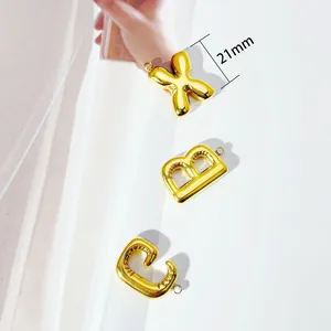 Detailed view of 18K gold-plated bubble letter pendants featuring a 21mm size mark