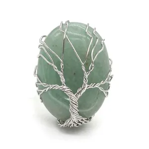 Close-up of green natural crystal oval ring with silver wire-wrapped tree of life design