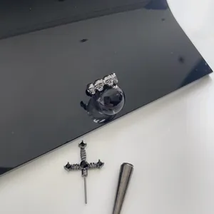 Gothic style jewelry set featuring a skull head ring and a black cross stud earring