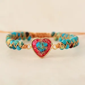 Détail d'un bracelet tissé à la main en pierre impériale avec un charme en forme de cœur