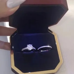 Detailed view of women's sparkling zircon ring set inside a premium red octagonal box