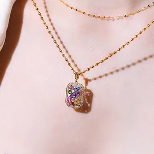 Gros plan du pendentif carré Secret Garden avec des pierres précieuses colorées et dorées.
