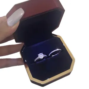 Elegant silver zircon wedding ring set presented in a luxury red velvet jewelry box