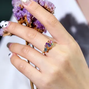 Gros plan détaillé d'une main portant une bague en pierres précieuses colorées plaquée or 18 carats