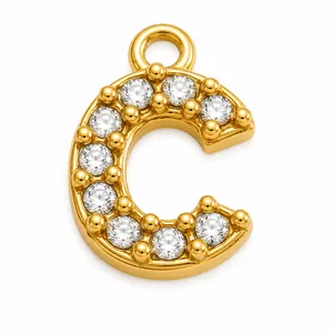 Detailed macro view of gold-plated stainless steel letter C pendant with crystals
