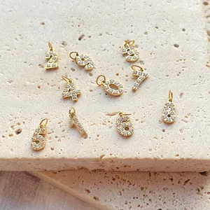 Set aus vergoldeten Edelstahlanhängern der Zahlen 0-9 mit Zirkonia-Kristallverzierung.