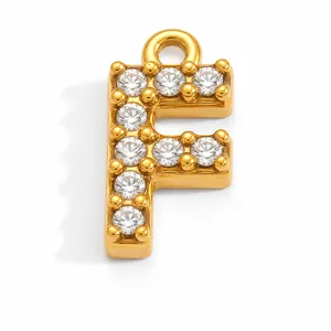 Detailed macro view of a gold plated stainless steel letter F pendant with shiny zircons