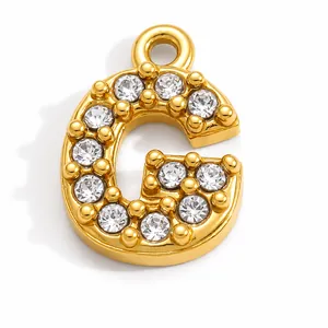 Macro view of a gold-plated stainless steel letter G pendant with sparkling rhinestones
