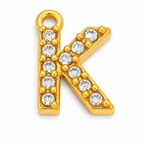Macro detail of a gold-plated letter K pendant with clear sparkling crystals