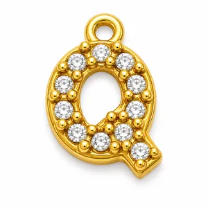 Macro detail of a gold-plated stainless steel letter Q pendant with pavé cubic zirconia