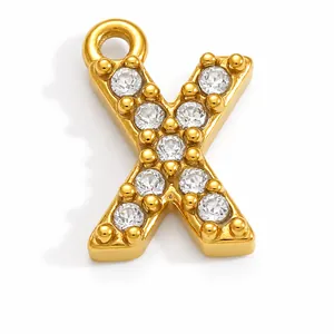 Macro view of gold-plated letter X pendant with clear cubic zirconia stone settings