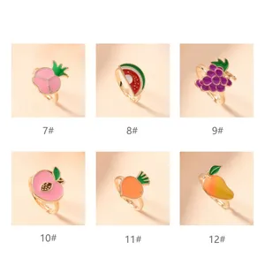 Close-up of six colorful fruit-shaped children's rings with unique enamel designs