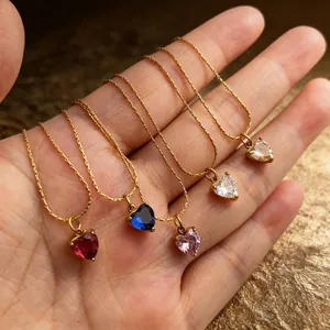 Detailweergave van vijf vintage hartvormige zirkonia kettingen in diverse kleuren op hand.