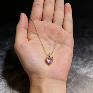 Detailopname van een vintage gouden ketting met een roze hartvormige zirkonia hanger