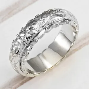 Detailansicht eines versilberten Rings mit aufwendigen Rosenblütengravuren