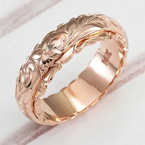 Detailansicht eines roségoldenen, verkupferten Rings mit eleganten floralen Gravuren.