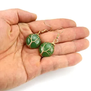 Dettaglio orecchini albero della vita fatti a mano con filo dorato e pietra verde
