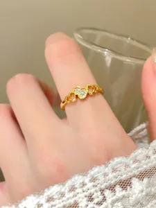 Primo piano di un anello a forma di zucca placcato oro con pavé scintillante