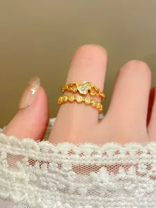 Primo piano di un anello a forma di zucca dorato con zirconi brillanti al dito