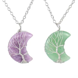 Détail rapproché de pendentifs lune arbre de vie en fil métallique et pierres naturelles