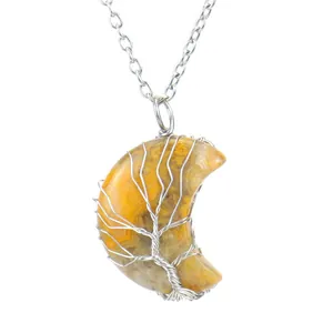 Gros plan du pendentif arbre de vie artisanal sur une lune en pierre naturelle jaune
