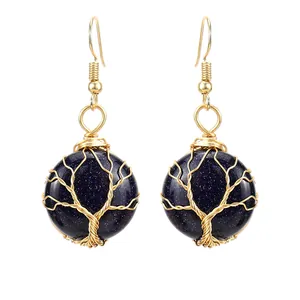 Dettaglio di orecchini Albero della Vita avvolti in filo d'oro con pietra blu.