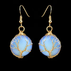Dettaglio di orecchini albero della vita fatti a mano in filo d'oro con pietra di opalite