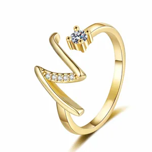 Close-up of a gold-plated letter 'V' ring featuring sparkling zircon stones and a minimalist band.