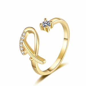 Detailed view of a gold-plated letter R open ring with sparkling cubic zirconia