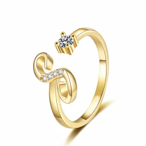 Detailed macro view of a golden S-shaped open ring with a sparkling zircon stone