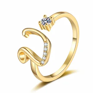 Close-up of elegant gold-plated open ring featuring letter 'V' and sparkling zircon accents