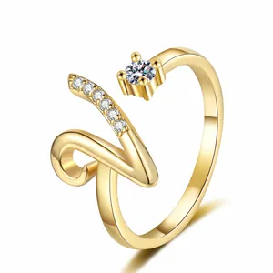 Detailed macro view of gold-plated open ring featuring a sparkling initial V design