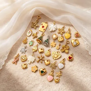 Vista detallada de varios dijes de acero inoxidable, corazones y árboles para joyería DIY.
