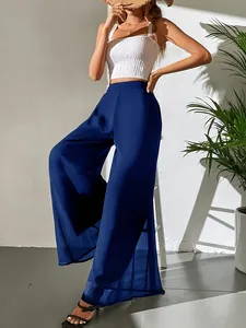 Détail d'un pantalon large en mousseline bleu marine au drapé élégant et taille haute.