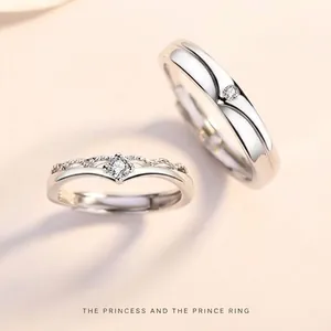 Primo piano dettagliato di anelli di coppia principe e principessa in argento 925 con zirconi.