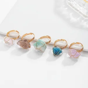 Macro detail of natural raw crystal rings with handcrafted gold wire wrapping style.