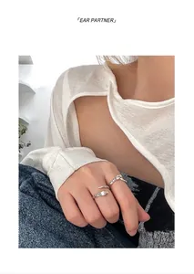 Close-up of vintage snake and rose engraved silver open rings shown on a model's hand
