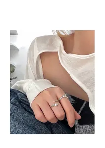 Close-up of vintage snake and rose engraved silver open rings shown on a model's hand