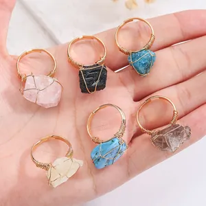 Macro detail of handmade natural irregular raw stone rings with gold wire wrapping