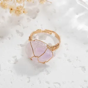 Macro view of a handmade wire-wrapped ring featuring an irregular purple stone