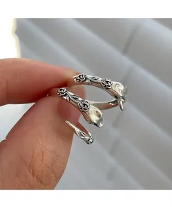 Detailed macro view of vintage silver snake ring featuring intricate rose floral patterns