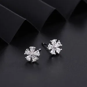 Primer plano de pendientes de flor de cerezo brillantes con pétalos de circón plata