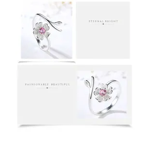 Primo piano di un elegante anello in argento 925 a fiore di ciliegio con pietra rosa