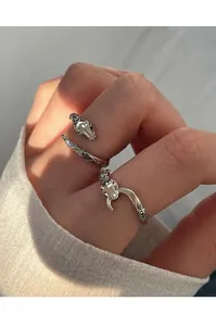 Detailed view of vintage silver snake ring with rose engraving worn on a finger model